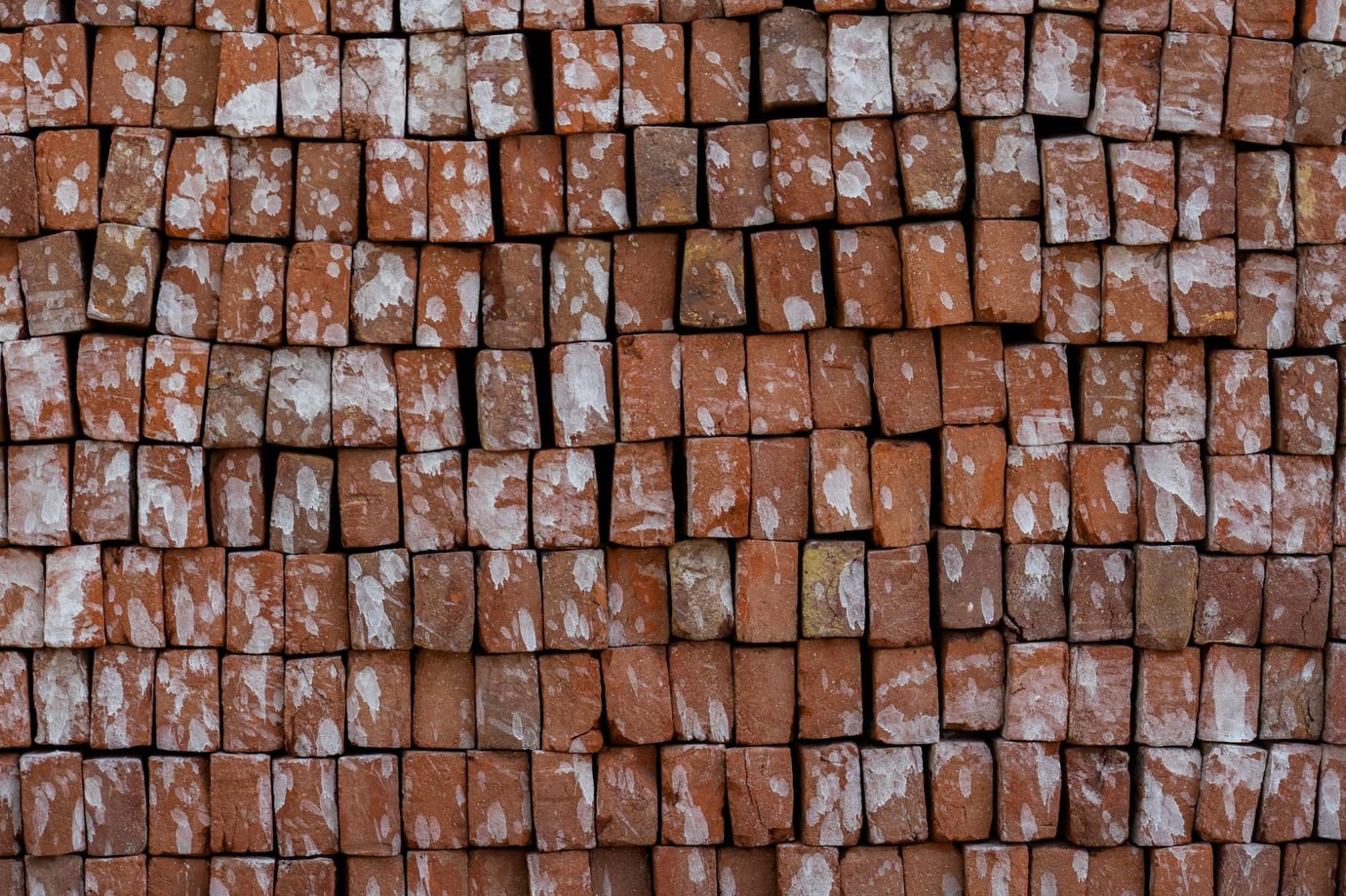 Pilha de tijolos cerâmicos vermelhos empilhados em paletes